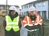 Two people in hi vis coats walking through The Courts, Shildon